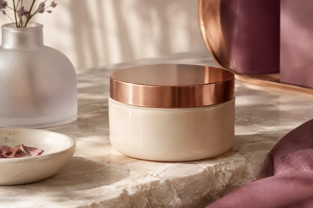 Pot ouvert de masque capillaire en gel posé sur une pierre claire, avec sa texture visible.