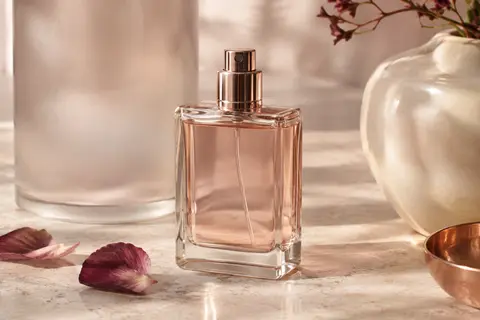 Flacon vaporisateur d’eau de parfum pour homme posé sur une pierre claire dans un décor ivoire