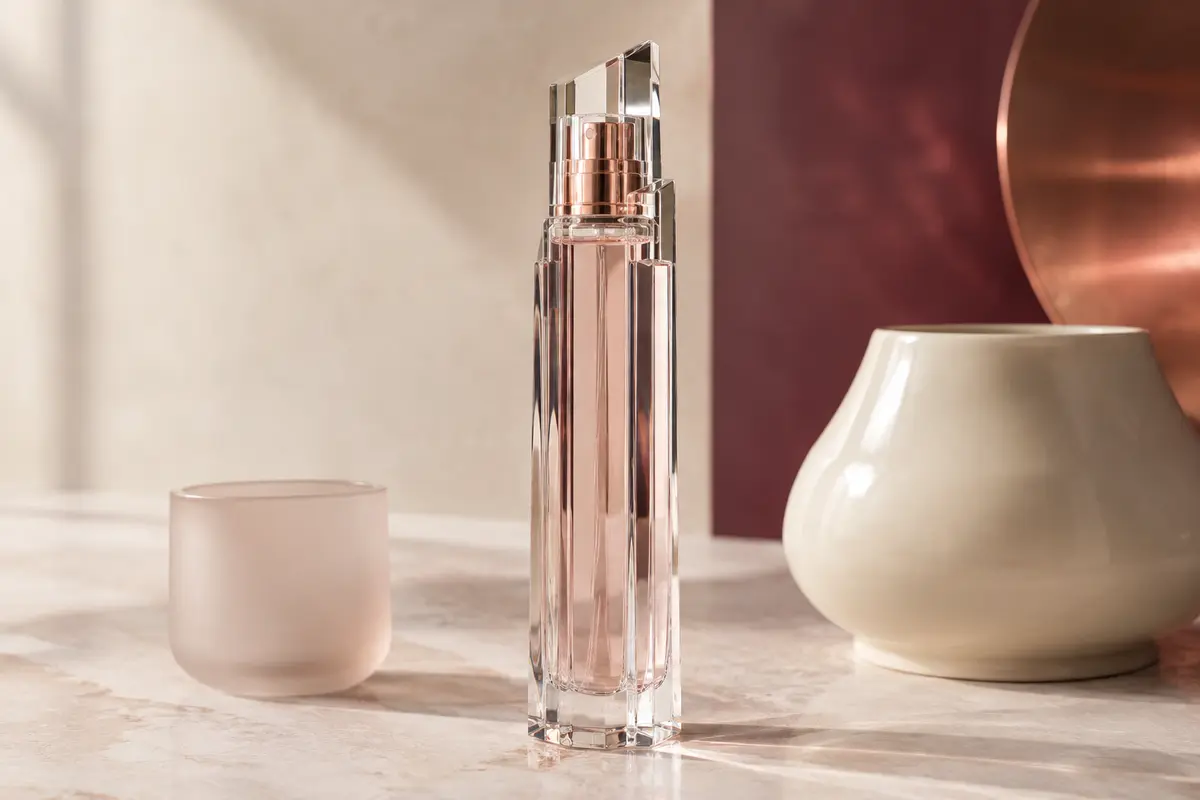 Flacon élancé de l’eau de parfum 5th Avenue posé sur une pierre claire dans un décor raffiné.