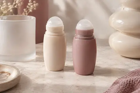 Deux flacons roll-on anti-transpirants posés sur une pierre claire dans un décor de beauté épuré.