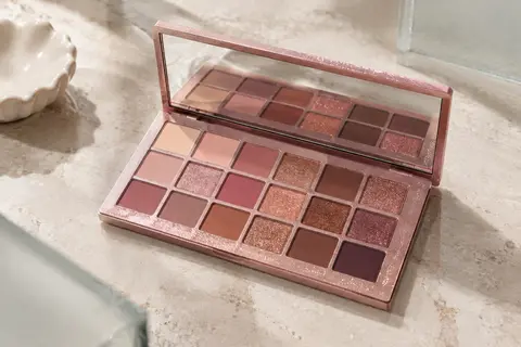 Palette de fards à paupières aux tons roses et chauds, ouverte sur ses 18 nuances et son miroir intégré.